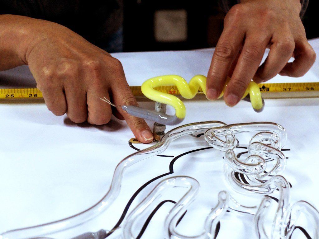 Мастер по производству неоновой рекламной вывески за работой