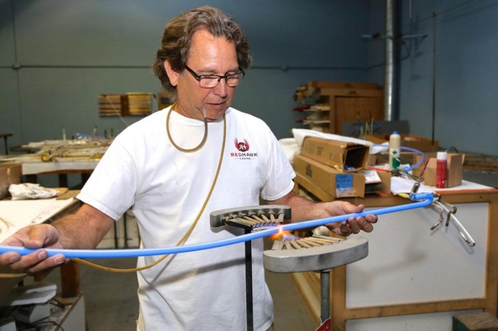 Мастер по изготовлению неоновой рекламной вывески за работой