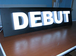 Вывеска компании DEBUT из белых световых объемных букв